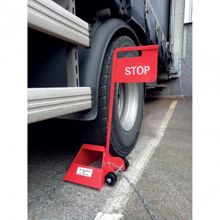 La cale de roue avec panneau STOP et chaîne antivol pour camion